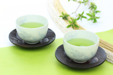 和紙の上の日本茶と若葉と水引