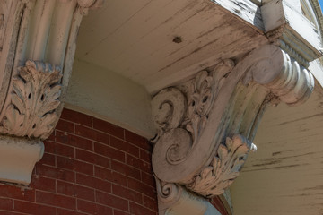 Detail of elaborate corbels beneath a curved balcony and brick wall, horizontal aspect © Natalie Schorr
