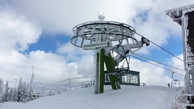 Moving ski chair lift station on mountain top in a sunny winter day