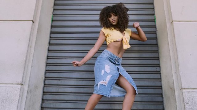 Modern style dancer with afro on her head dancing on street