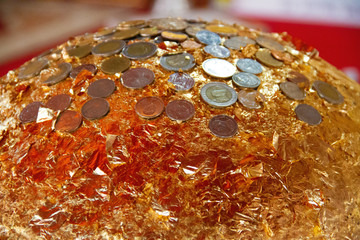 Buddhism round stone ball stick with gold leaf and coins on top of it call is 