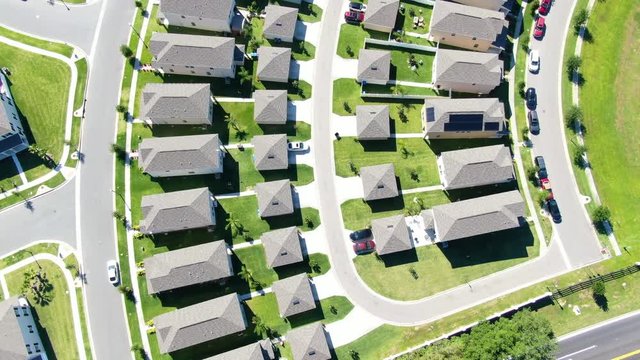 Zoom out and flight over homes with green lawns, beautiful neighborhood