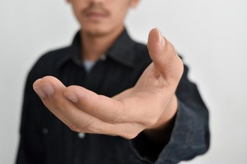 Close-up view of businessman hand reached out to handshake blurred in background.