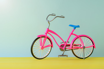 Fototapeta premium Toy red bike for a yellow and blue background.