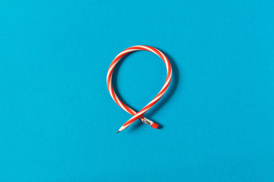 Flexible pencil . Isolated on blue background. Bending pencil.