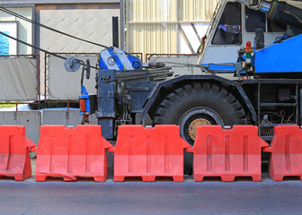 Red plastic barriers blocking near the road during construction.