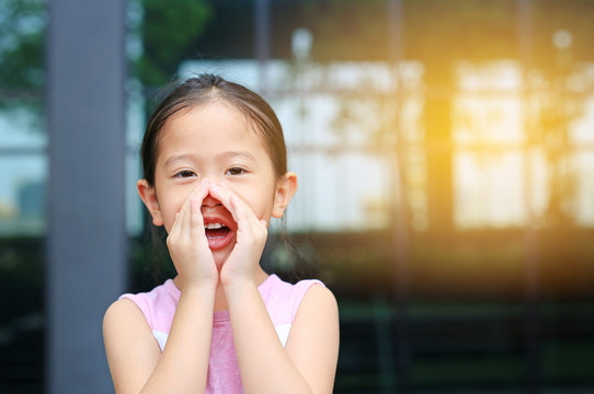 Portrait Little Asian Child Girl Acting And Shouting Through Hands Like Megaphone. Communication Concept.