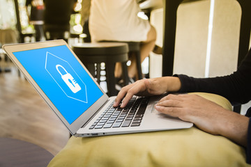 Business man working at a coffee shop with a laptop. elect the icon security on the virtual display.