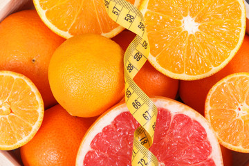Fresh juicy fruits as source minerals or vitamins and tape measure. Dieting, slimming and healhy lifestyles