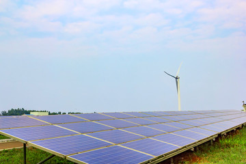 Solar power photovoltaic panels and wind generator under the blue sky white clouds.