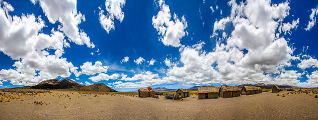 A panorama of a bolivian famming village on the altiplano under a big blue sky