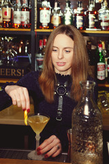 Bartender-girl mixing cocktail behind the counter