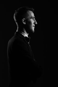 Portrait of a young  man in profile on a dark background.