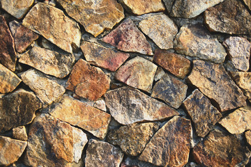 Background texture of natural cracked rock stone wall.