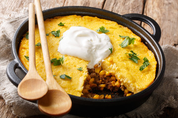 Homemade tamale pie casserole with corn and ground beef and cheese close-up in a frying pan....