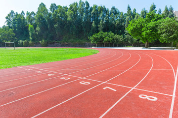 Outdoor track and field stadium runway under the blue sky.