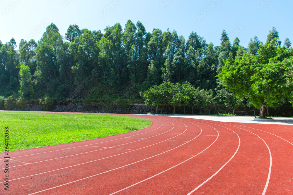 Wall mural Outdoor track and field stadium runway under the blue sky.