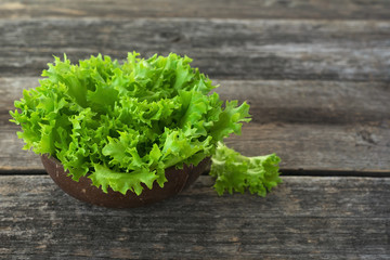 fresh lettuce leaves in a bowl on wooden background