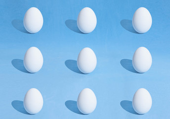  Food background made of white Easter eggs on a blue backdrop