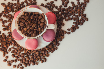  White cup of coffee. Sweets and coffee on a white background. Macaroons with coffee for dessert. Coffee beans