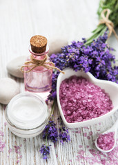 Fototapeta na wymiar Heart-shaped bowl with sea salt, oil and fresh lavender flowers