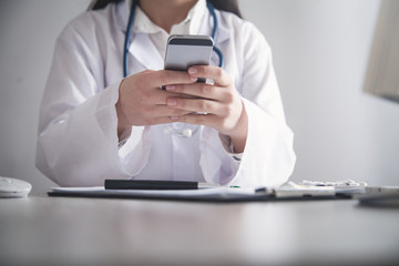Doctor using mobile phone at clinic.