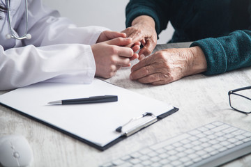 Doctor holding patient hands in hospital. Patient care