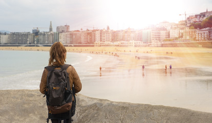 Fototapeta premium Chica mirando la playa de la Concha con gente en la ciudad de San Sebastian