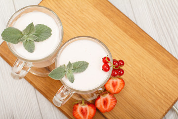 Delicious strawberry yogurt with mint leaves in glasses.