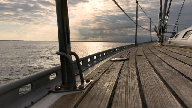 View from a super yacht as it sails across crystal clear New Zealand seas while the sun is setting.