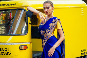 portrait indian beautiful Caucasian woman in traditional blue dress.hindu model with golden kundan...