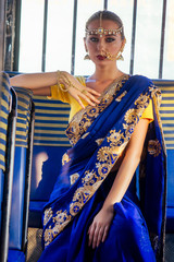 portrait indian beautiful Caucasian woman in traditional blue dress.hindu model with golden kundan...