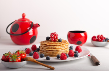pancakes with raspberries and blueberries on a white background