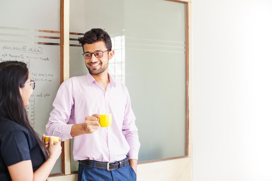 Two indian colleagues talking over cup of coffee