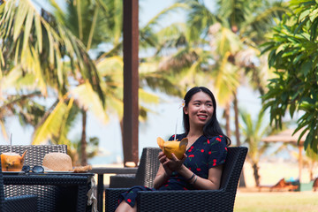 Woman with coconut on a tropical beach