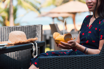 Woman with coconut on a tropical beach