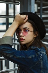 portrait of attractive young woman in stylish glasses and hat