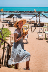 Obraz na płótnie Canvas Woman with coconut on a tropical beach