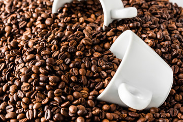 Pattern of roasted coffee beans with two white coffee cups