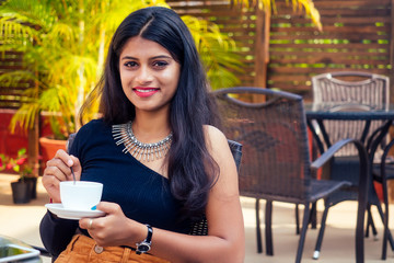 coffee break idea.Young indian businesswoman using tablet computer in summer garden cafe