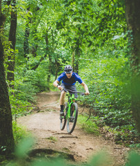 Man mountain bikes in forest
