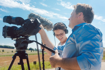 Cameraman with his camera and assistant working in production