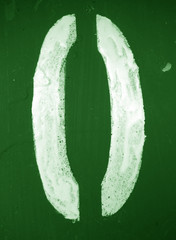 Number 0 in stencil on metal wall in green tone.