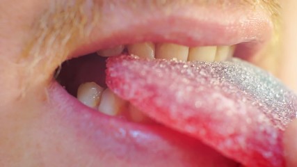 male mouth eating bright gummy candy marmalade.extreme close-up.shallow depth of field.