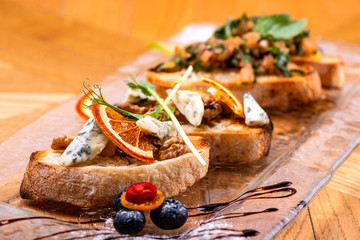 Delicious Italian antipasti bruschetta on wooden table. Close-up.