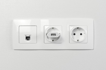Electrical sockets on the wall with black connection internet plug and white wire. Adapter from the...
