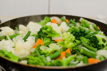Vegetable stew. Cooking stewed vegetables, broccoli and young beans in a frying pan.