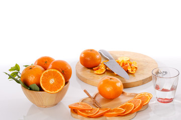 golden orange is placed in a wooden on white table