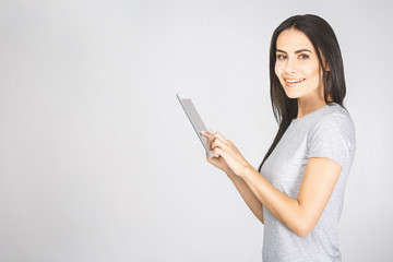 Portrait with copy space empty place of pretty charming confident trendy woman in casual having tablet in hands looking at camera isolated on white background.