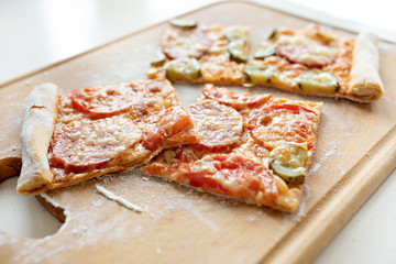 Pizza with mozzarella cheese, salami, tomatoes and spices. Italian pizza on a wooden board. Close-up
